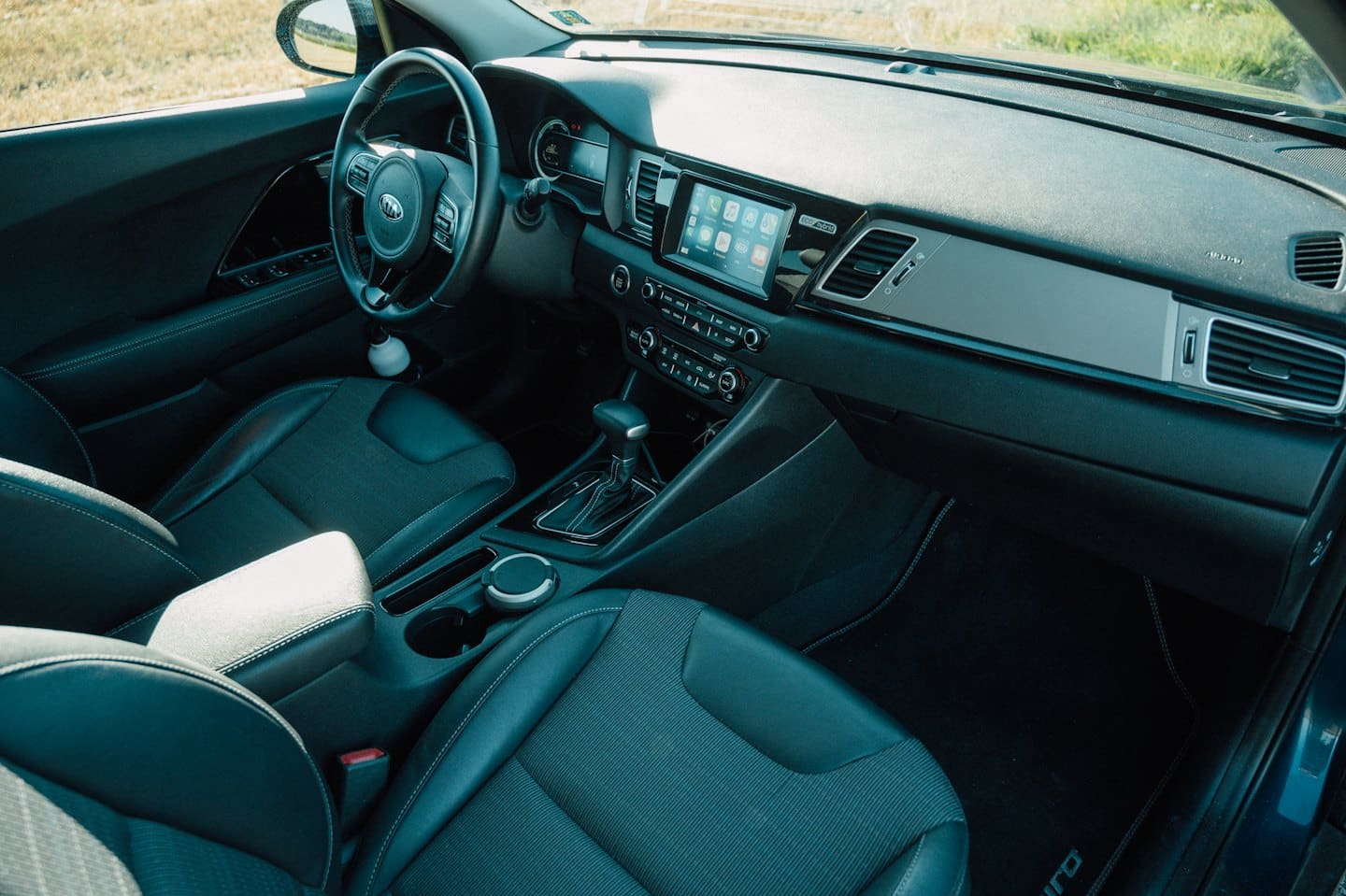 Modernes Autoinnenleben mit Ledersitzen und zentralem Touchscreen.