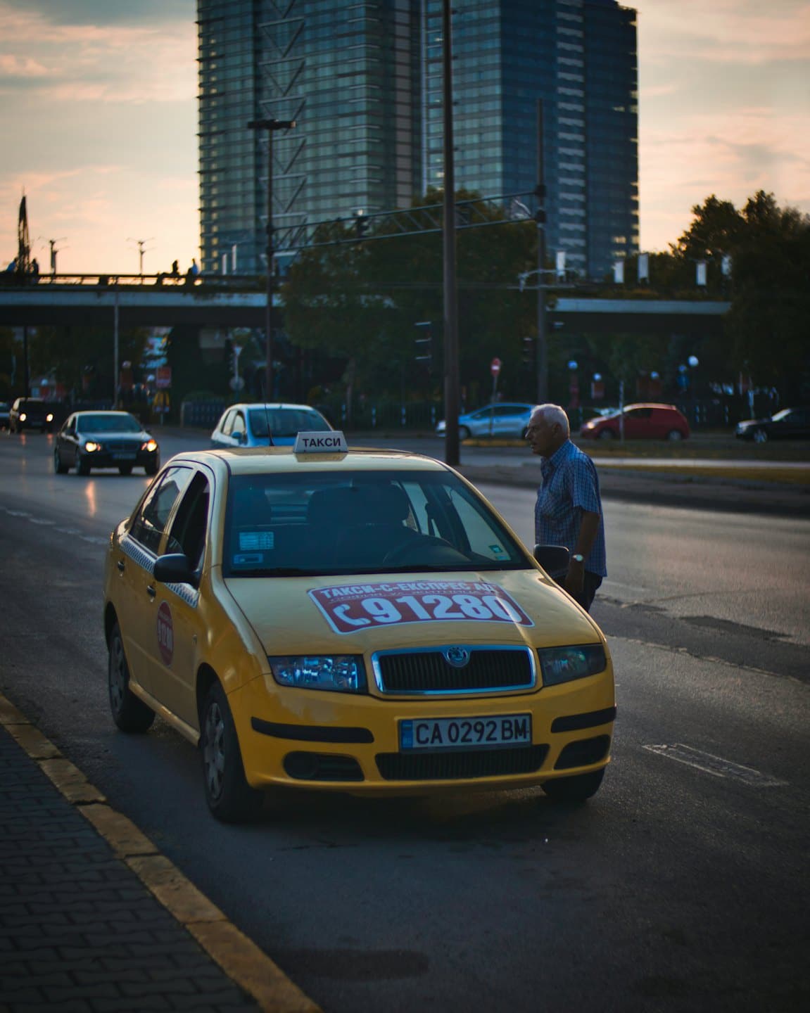 Mann im karierten Hemd steigt in ein Taxi.